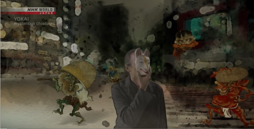 Professor Foster holding a mask, surrounded by yokai illustrations 